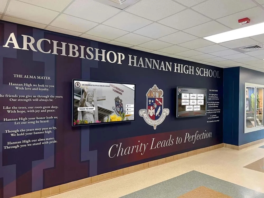 School lobby featuring artistic mural with digital recognition screens