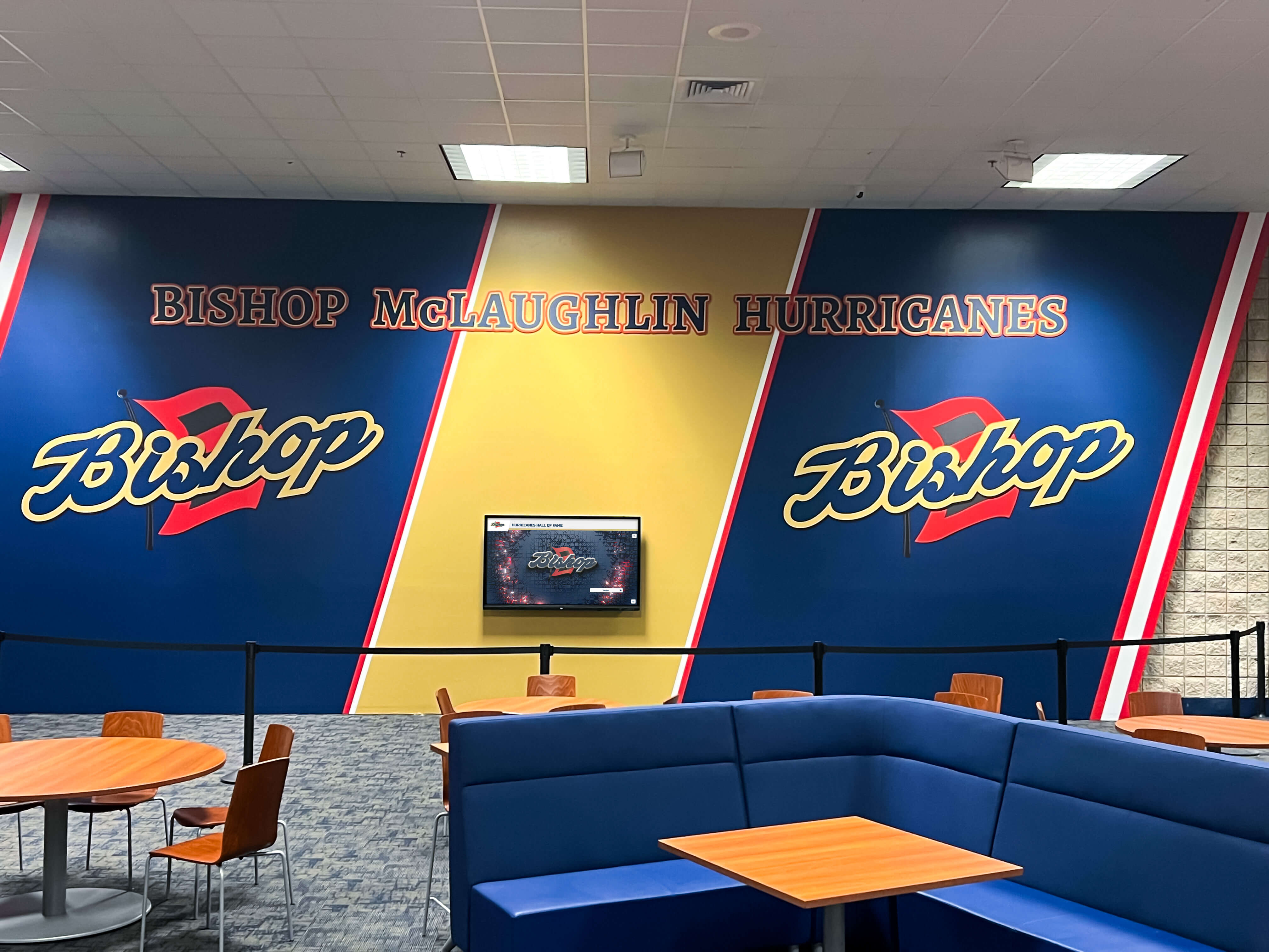School cafeteria athletic lounge with comprehensive sports recognition mural