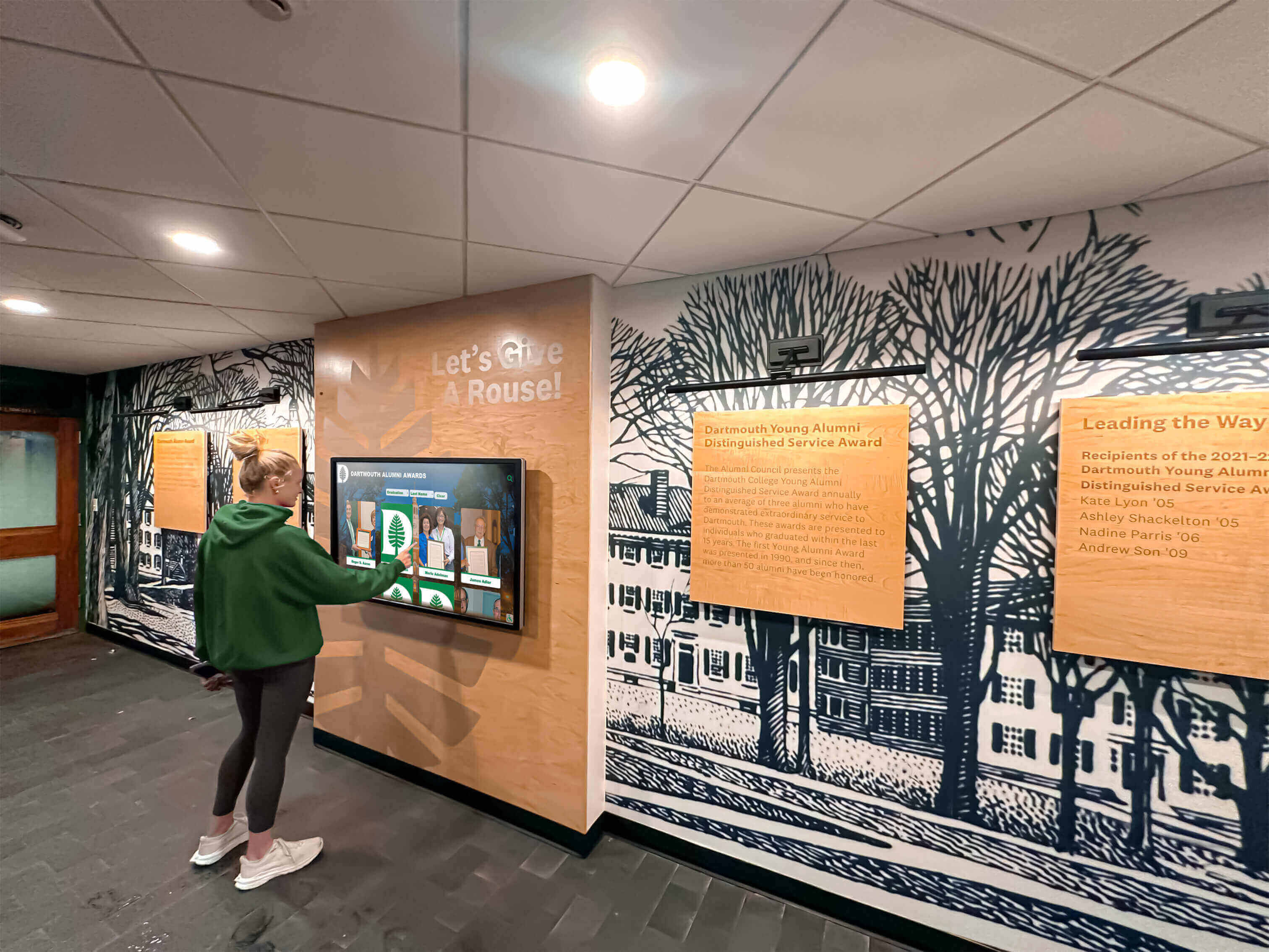 Student exploring alumni achievements on interactive recognition display